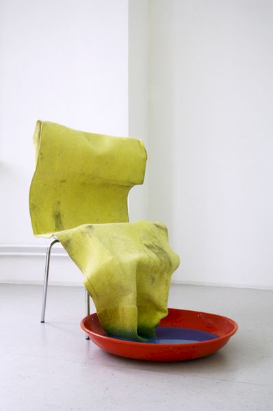 Fussbadende (Foot bath) | The same oversized swamp rag sits on a chair, takes a foot bath in coloured water.(Installation view at Kunstsaele, Berlin 2012)